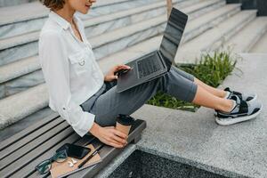 attractive business woman working outside on laptop photo