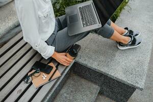 attractive business woman working outside on laptop photo