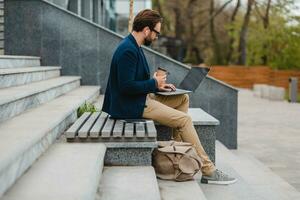 handsome busy bearded man working in park photo