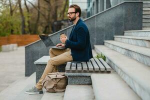 handsome busy bearded man working in park photo