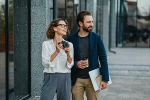 man and woman business partners working together in park photo