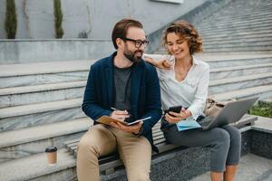 man and woman working together in park photo