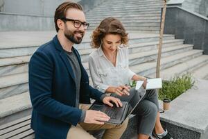 man and woman working together in park photo