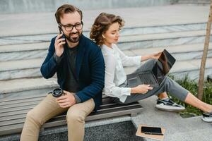 man and woman working together in park photo