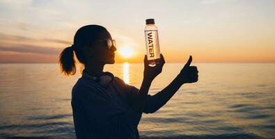 mujer a mar participación botella de agua foto