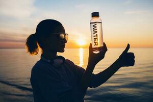 mujer a mar participación botella de agua foto