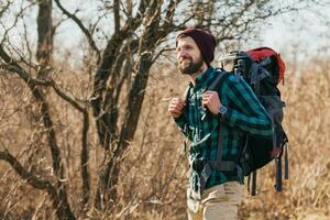 joven hipster hombre de viaje con mochila en primavera otoño bosque foto