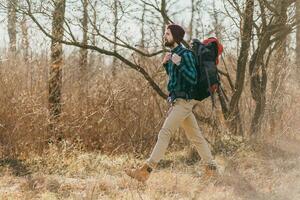 joven hipster hombre de viaje con mochila en primavera otoño bosque foto