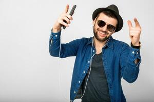 young handsome happy smiling man listening to music in earphones photo