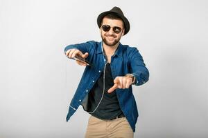 young handsome happy smiling man listening to music in earphones photo