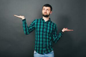 joven hermoso hipster barbado hombre en gris antecedentes foto