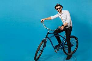 young handsome smiling happy man traveling on hipster bicycle photo