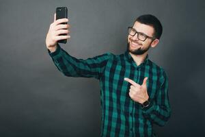 joven hermoso hipster barbado hombre en gris antecedentes foto