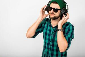 young handsome happy smiling man dancing and listening to music in headphones photo