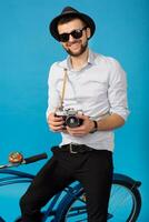 young handsome smiling happy man traveling on hipster bicycle photo