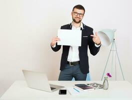 young handsome stylish hipster man in black jacket working at office table, business style photo