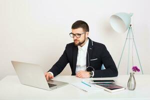 young handsome stylish hipster man in black jacket working at office table, business style photo