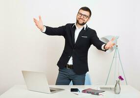 young handsome stylish hipster man in black jacket working at office table, business style photo