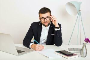 young handsome stylish hipster man in black jacket working at office table, business style photo