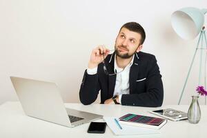 young handsome stylish hipster man in black jacket working at office table, business style photo