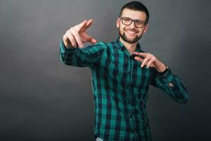 young handsome hipster bearded man on grey background, green checkered shirt photo