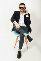 young handsome stylish hipster man in black jacket working at office table, business style photo