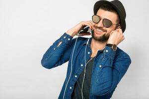 young handsome happy smiling man listening to music in earphones photo