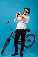 young handsome smiling happy man traveling on hipster bicycle photo