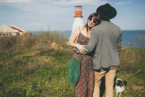 joven elegante hipster Pareja en amor caminando con perro en campo foto