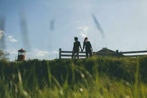 young stylish hipster couple in love walking with dog in countryside, having fun photo