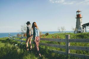 young stylish hipster couple in love walking with dog in countryside, having fun photo