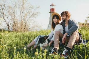 young stylish hipster couple in love walking with dog in countryside, having fun photo