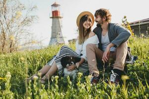 young stylish hipster couple in love walking with dog in countryside, having fun photo