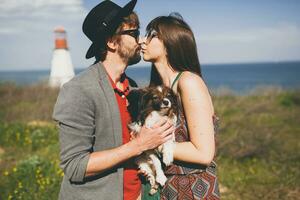 lovely smiling young stylish hipster couple in love walking with dog in countryside photo