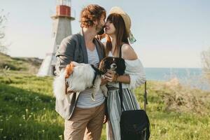 sitting in grass young stylish hipster couple in love walking with dog in countryside photo