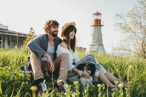 sitting in grass young stylish hipster couple in love walking with dog in countryside photo