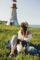 pretty stylish woman in countryside, holding a dog photo