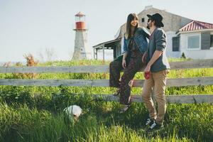 stylish hipster couple in love walking with dog in countryside photo