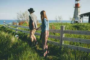 stylish hipster couple in love walking with dog in countryside photo