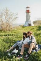 stylish hipster couple in love walking with dog in countryside photo