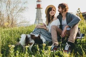 stylish hipster couple in love walking with dog in countryside photo