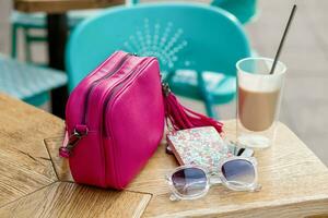 objects arranged on table in city cafe in street, woman accessories photo