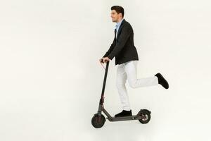 handsome man riding on electic kick scooter isolated on white studio background photo