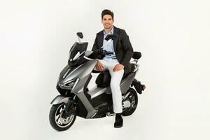 handsome man riding on electic motorbike scooter isolated on white studio background photo