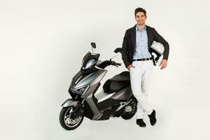 handsome man riding on electic motorbike scooter isolated on white studio background photo