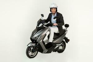 handsome man riding on electic motorbike scooter isolated on white studio background photo