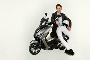 handsome man riding on electic motorbike scooter isolated on white studio background photo