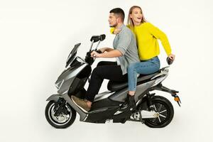 young attractive couple riding an electric motorbike scooter happy having fun together photo