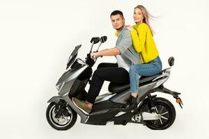 young attractive couple riding an electric motorbike scooter happy having fun together photo