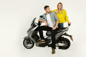 young attractive couple riding an electric motorbike scooter happy having fun together photo